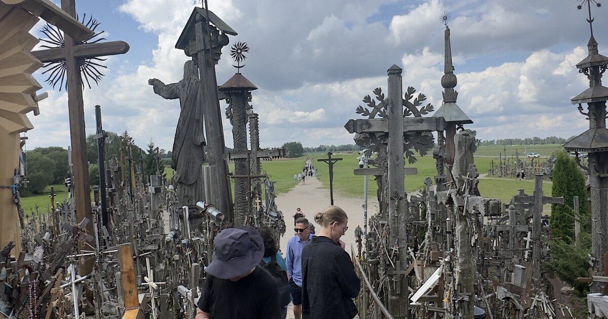 Colline des Croix, Lituanie — passerelle avec la statue du Christ et croix sculptées à la main.