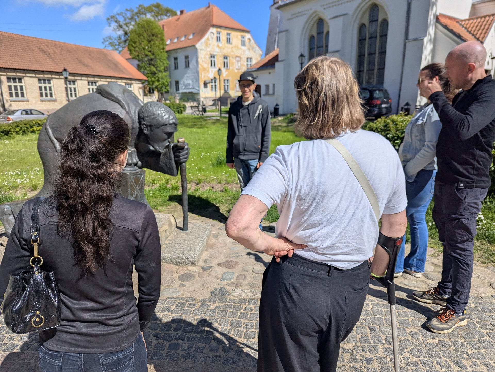 Groupe autour de la sculpture en bronze du pèlerin dans la vieille ville de Cēsis