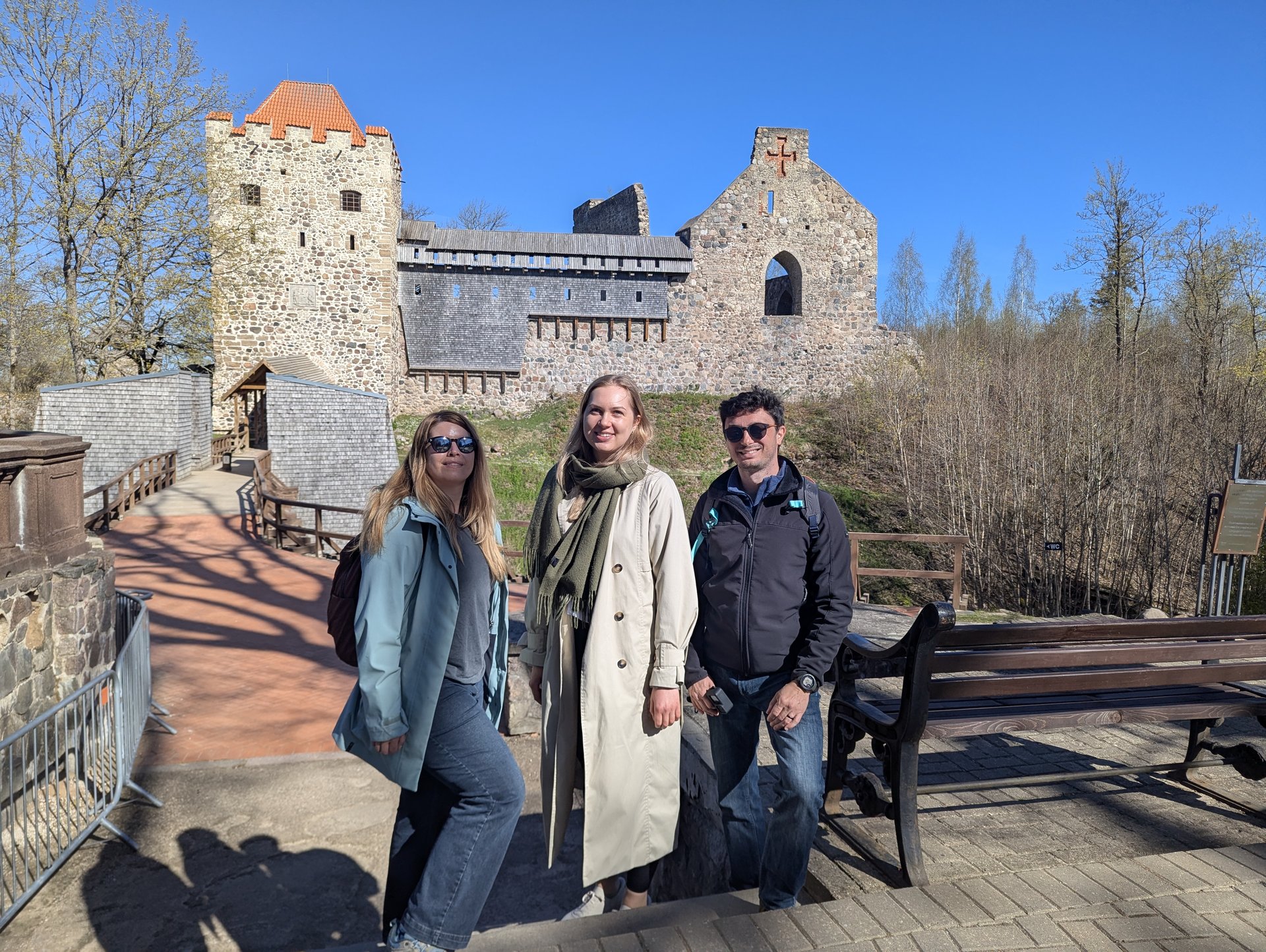 Invités de Barefoot Baltic posant devant les ruines du château médiéval à Sigulda
