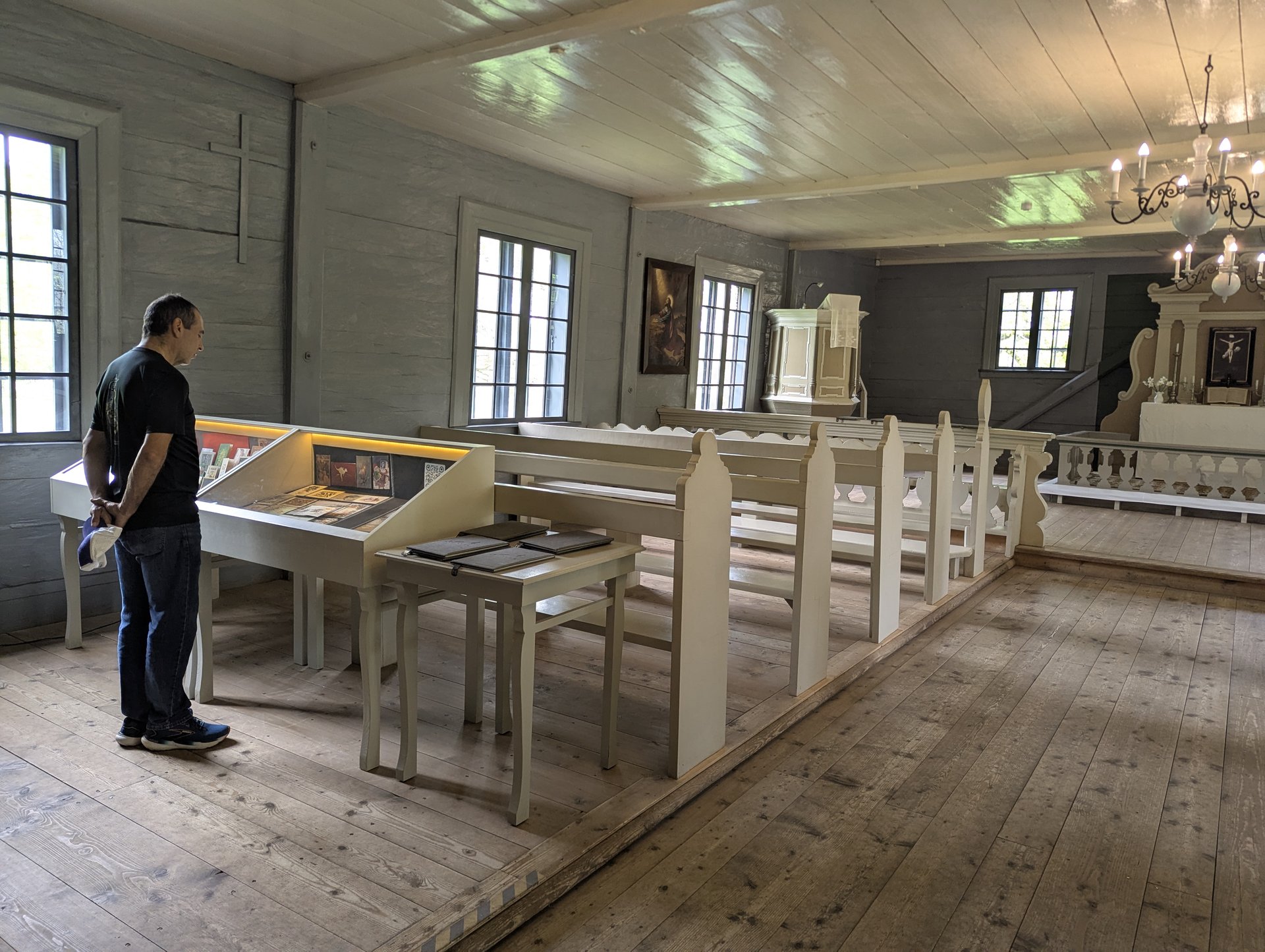 Intérieur du musée-église en bois de Vidzeme, un visiteur devant les expositions